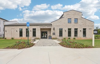 The leasing office and resident clubhouse with a pool in the background.