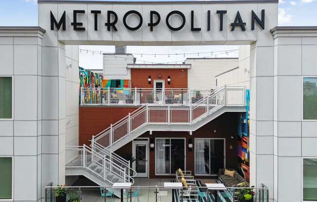 the front of a metropolonica building with tables and chairs