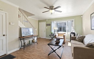 a living room with a couch and a ceiling fan