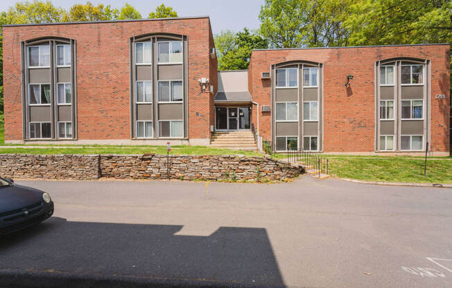 the front of a red brick building with a parking lot at Springwood Gardens, New Britain