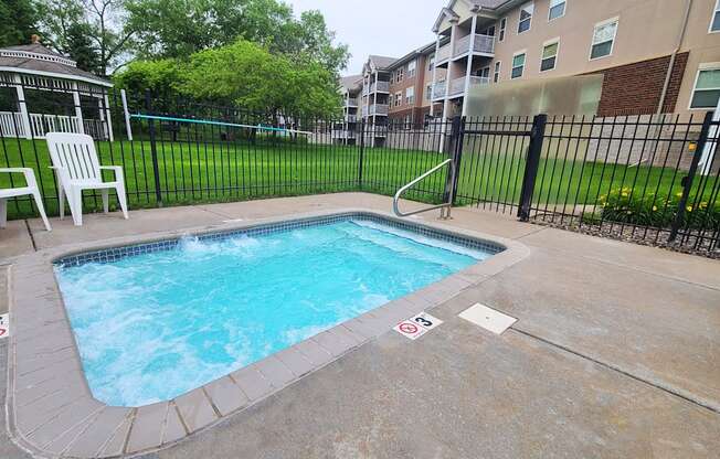 a swimming pool in a fenced in area of an apartment building