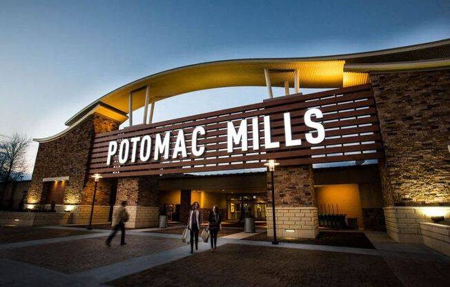 people walking outside of the potomac mills building at night