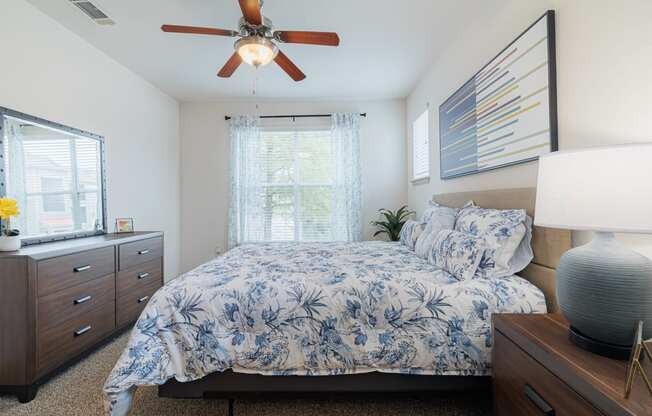 a bedroom with a bed and a ceiling fan