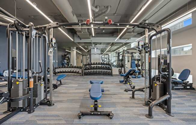 a spacious fitness center with cardio equipment and weights