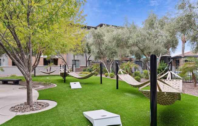 A backyard with a white hammock and a white bench. at The Laurel Apartments, Chandler Arizona