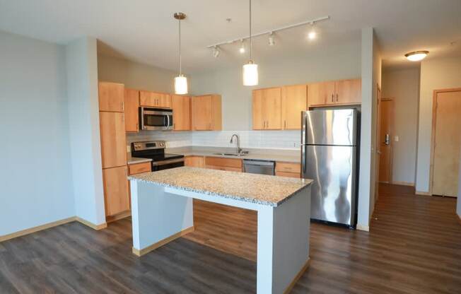 A kitchen with wooden cabinets and a granite countertop.