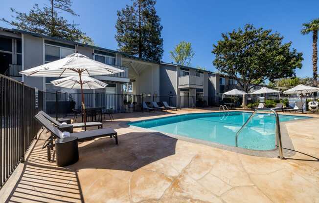 our apartments have a swimming pool and a patio with chairs and umbrellas at Campbell West Apartments, Campbell, 95008