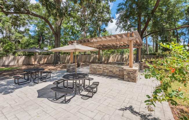 a patio with a pergola and tables with umbrellas