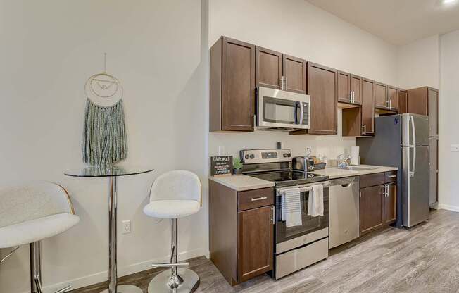 A kitchen with a white wall and a wooden cabinet.