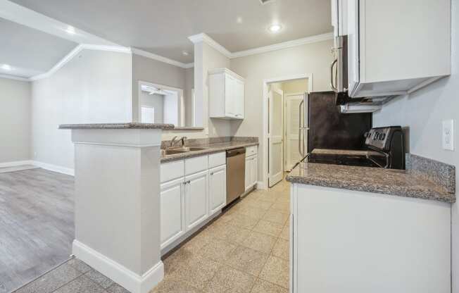 a kitchen with white cabinets and a counter top and a sink