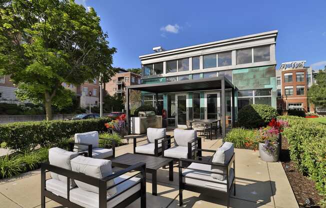 a patio with chairs and tables and a building in the background