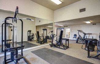 a gym with exercise equipment and mirrors on the wall