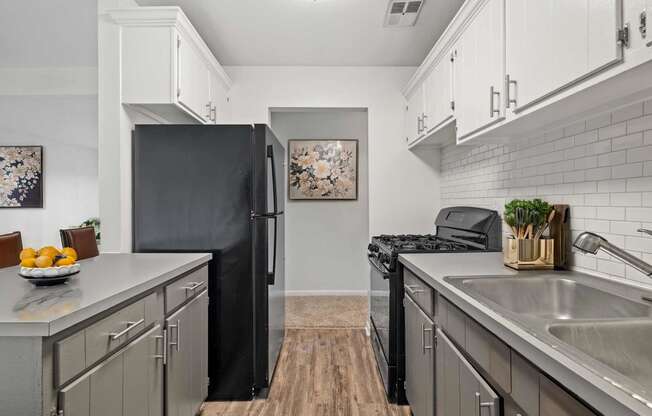 a kitchen with stainless steel appliances and a black refrigerator