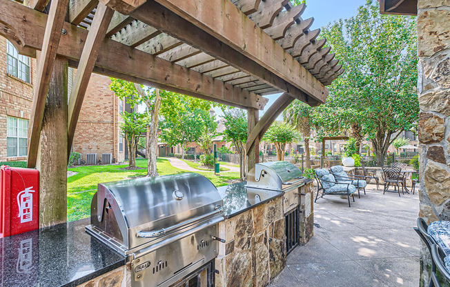 A patio with a grill and seating area.