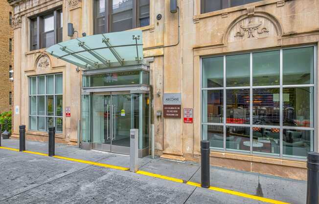 the facade of a building with a glass door and a sidewalk