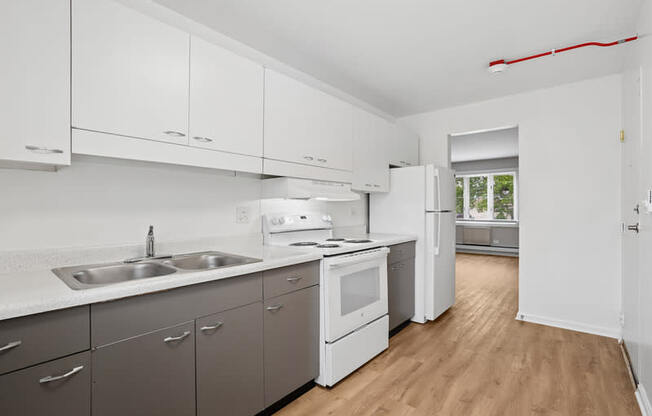 A kitchen with white cabinets and a window.