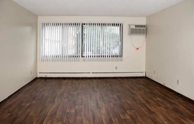 Large windows, air conditioning unit, vinyl flooring throughout living space