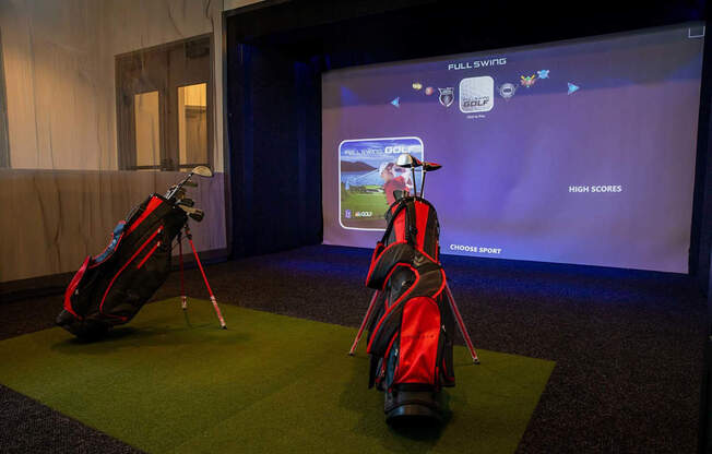 a display of golf clubs and bags in front of a screen
