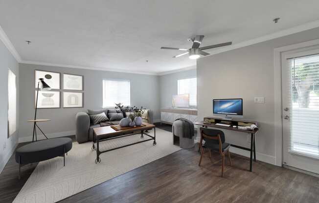 a living room with a ceiling fan and a tv