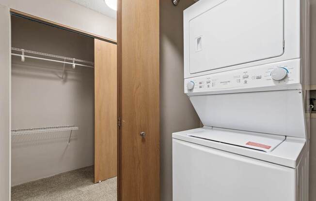 A white dryer is in a small laundry room.