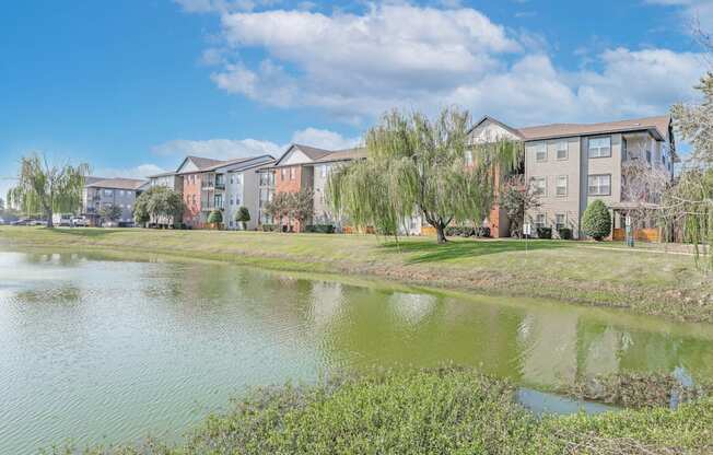 A row of apartment buildings with a pond in front at Ultris Island Park in Shreveport, LA