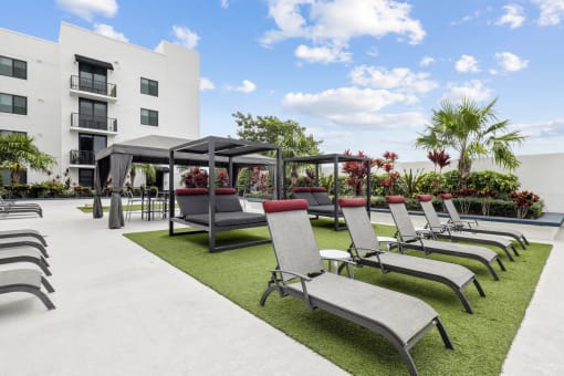 a row of lounge chairs and umbrellas in front of a building