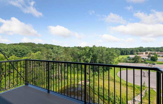 a balcony with a view of a field and trees