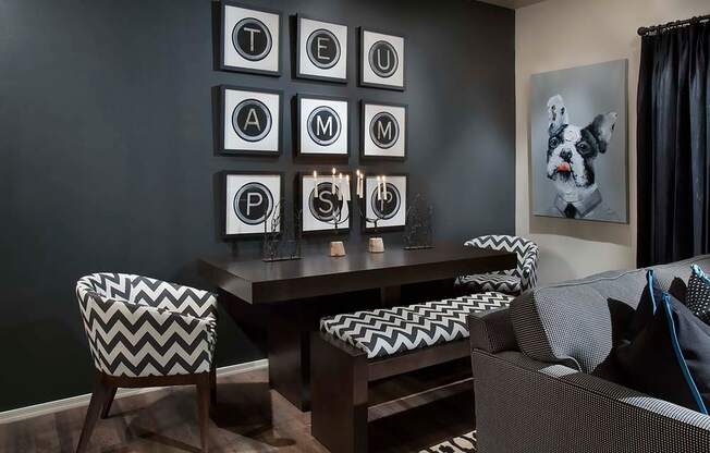 a living room with a table and chairs and pictures on the wall