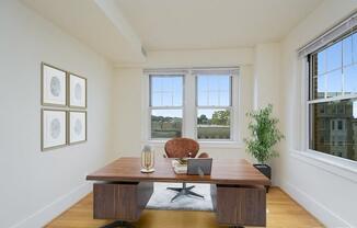 a home office with two windows and a wooden desk