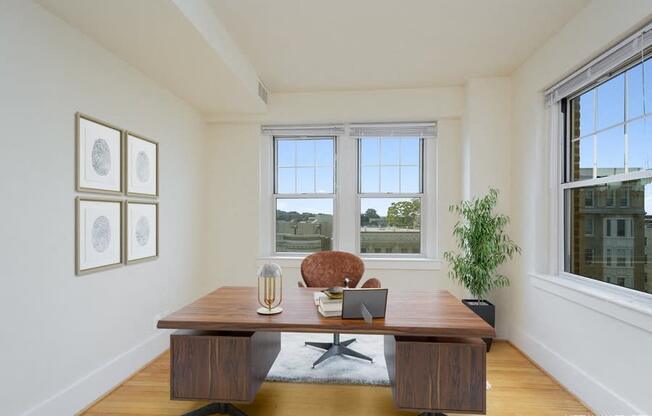 a home office with two windows and a wooden desk