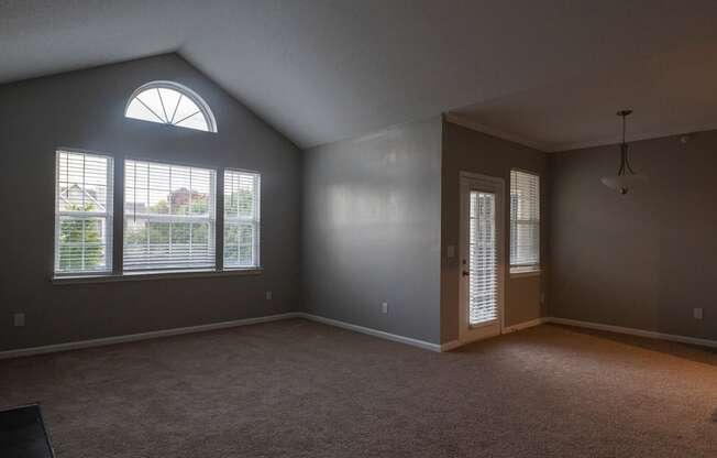 an empty bedroom with a large window and a door