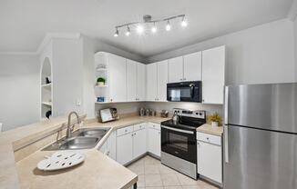 a modern kitchen with stainless steel appliances and white cabinets