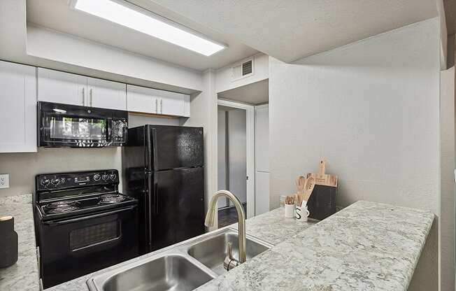 a kitchen with granite countertops and black appliances