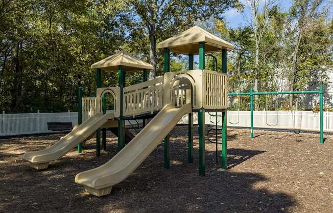 A playground with a yellow slide and a green roof.
