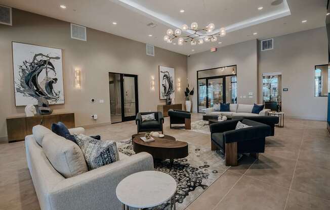 Large Clubhouse with a grey sofa, a wooden coffee table, and a chandelier.
