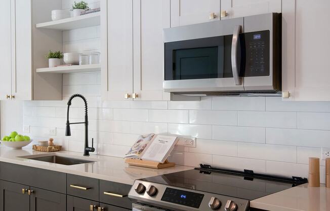 Sophisticated white countertops with subway tile backsplash and dark cabinets at Novel Cary