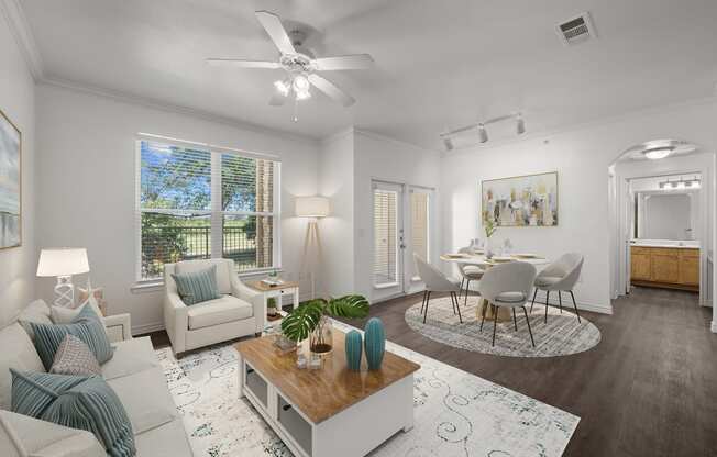 a living room and dining room with white furniture and a ceiling fan