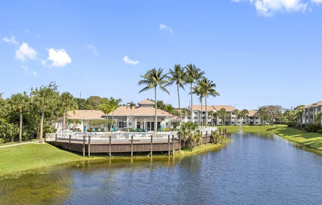 a house on the water with a pool and palm trees