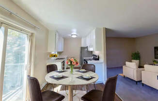 A dining room with a table set for two and chairs around it.