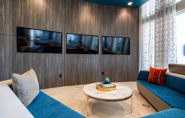 A living room with a white couch and a blue cushion.