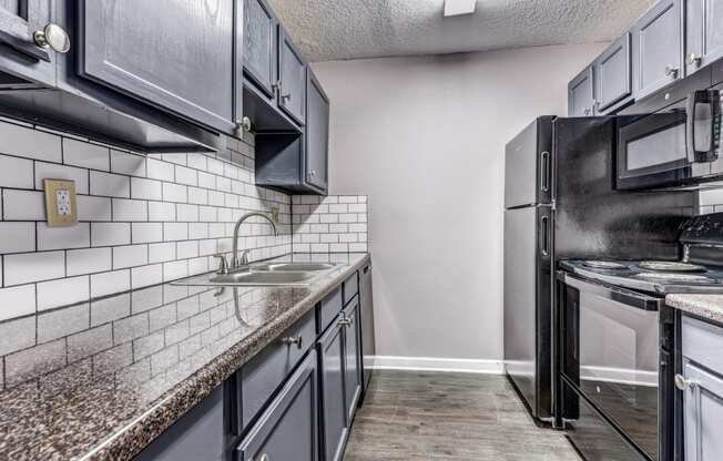 Whitney Manor Apartments in Gretna, LA photo of kitchen with subway tile back splash and hardwood floors