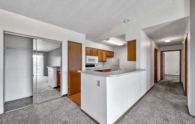 an empty kitchen with a counter top and a refrigerator