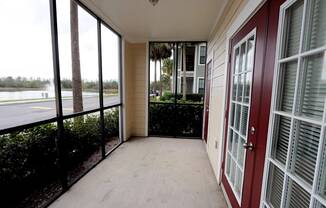 A balcony with a view of a body of water and trees.