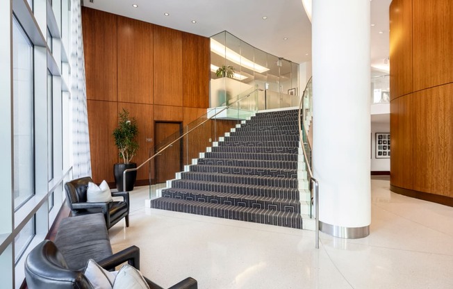 the lobby of a building with a large staircase and furniture