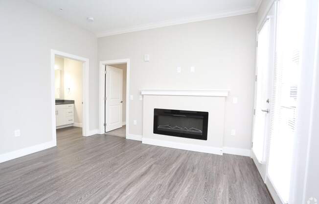 a living room with a fireplace and a door into a bedroom at Century Baxter Avenue, Louisville Kentucky