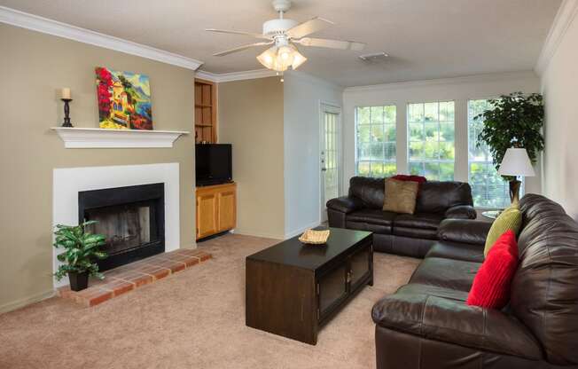 Living area with fireplace and large windows at Regency Gates in Mobile, AL