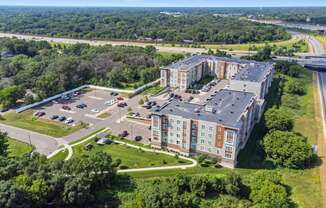 an aerial view of an apartment building next to a highway