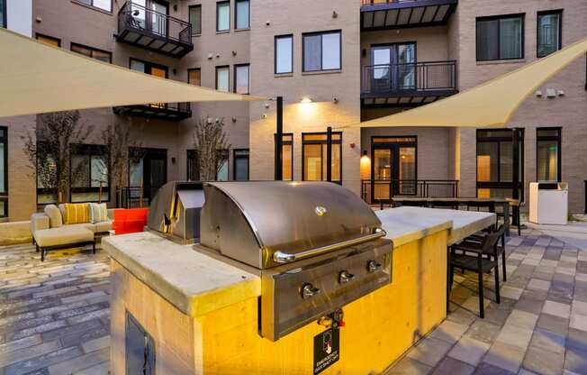 Pet-Friendly Apartments In Wheat Ridge, CO - The Parallel - Grill Area With BBQs, Couches, Tables, And Chairs