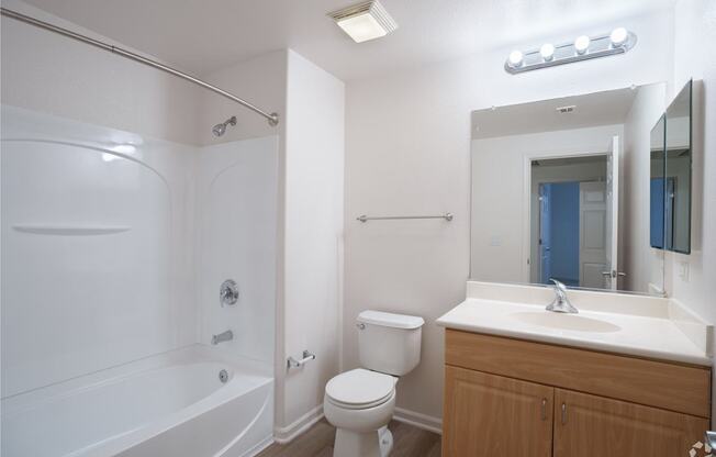 A white bathroom with a toilet, sink, and bathtub at Cornerstone at Gale Ranch Apartments, California, 94582