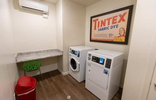 a laundry room with two washers and a dryer